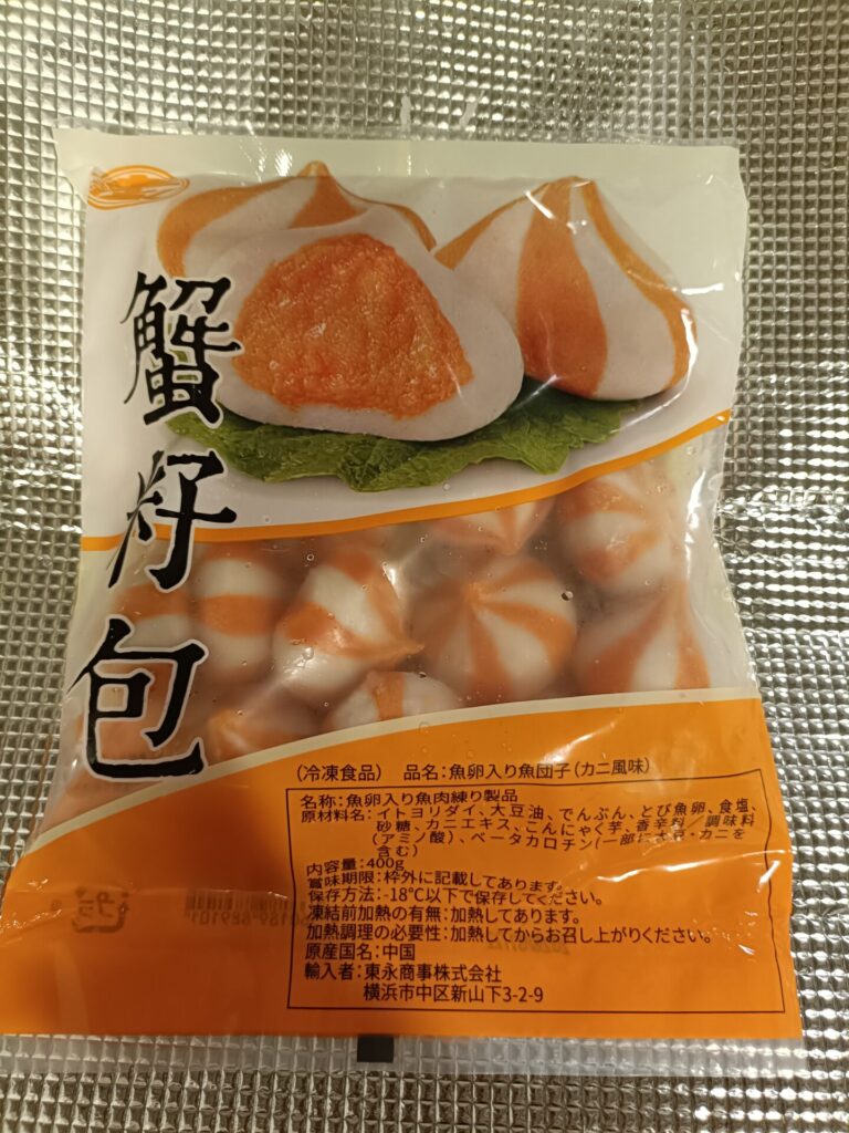 蟹子包のパッケージ越しに見える、オレンジと白のシマシマ模様の団子