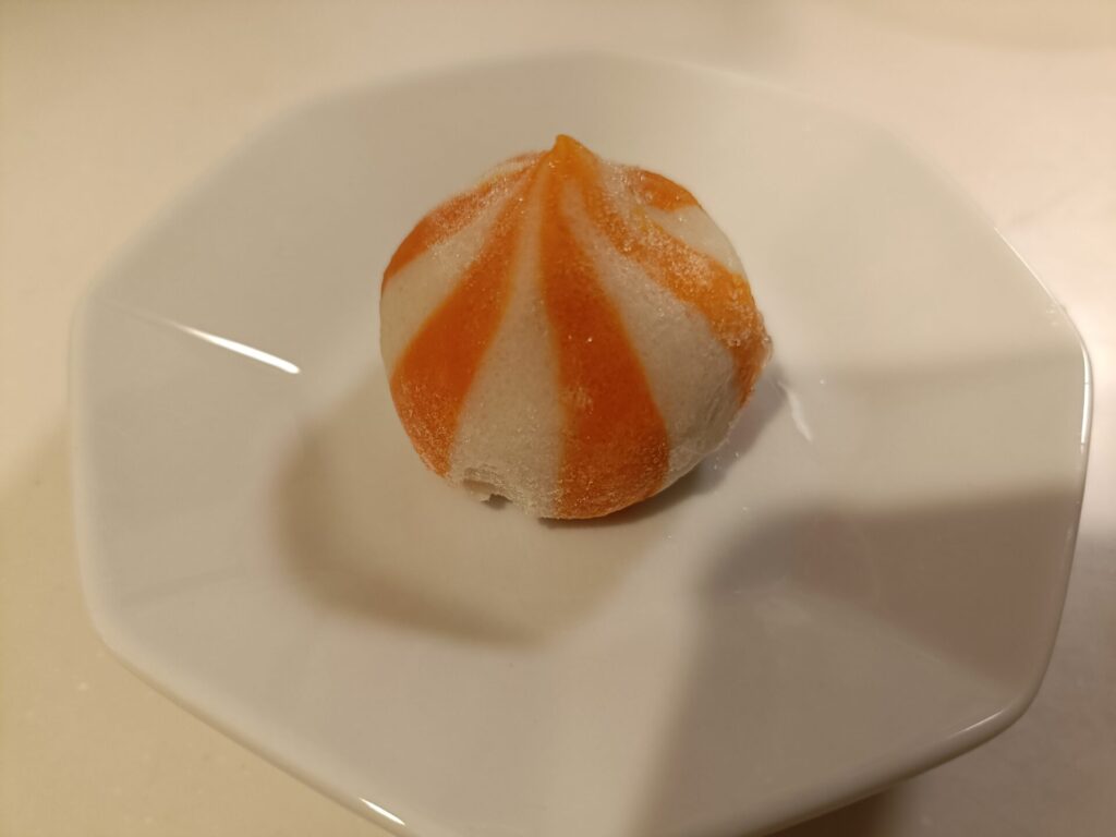 冷凍状態の蟹子包を1粒、白い皿にのせたところ